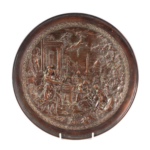 407 - A copper dish decorated in relief with a Neo-classical scene, 31cms diameter.