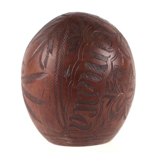 408 - A coconut shell carved Jamaica, palm trees and other leaves, 12cms high.