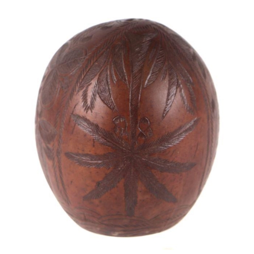 408 - A coconut shell carved Jamaica, palm trees and other leaves, 12cms high.