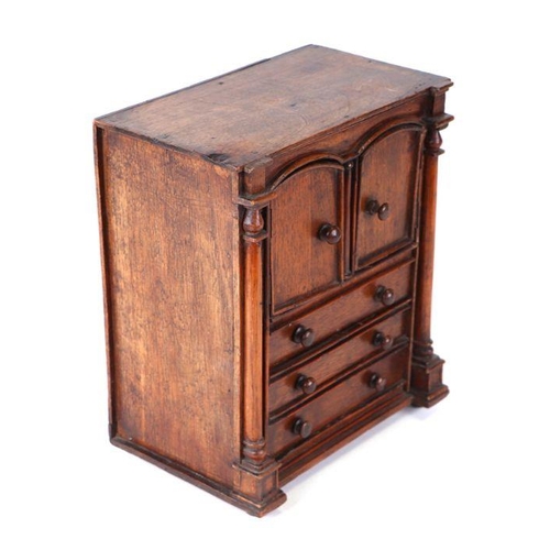 422 - A 19th century apprentice piece, a miniature cabinet, the pair of cupboard doors above three long dr... 