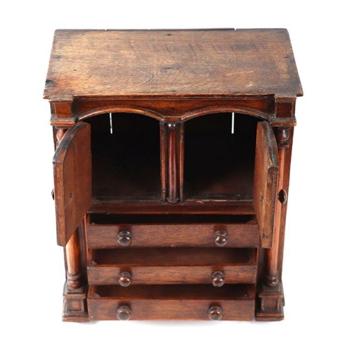 422 - A 19th century apprentice piece, a miniature cabinet, the pair of cupboard doors above three long dr... 