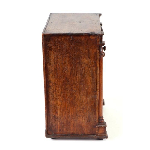 422 - A 19th century apprentice piece, a miniature cabinet, the pair of cupboard doors above three long dr... 