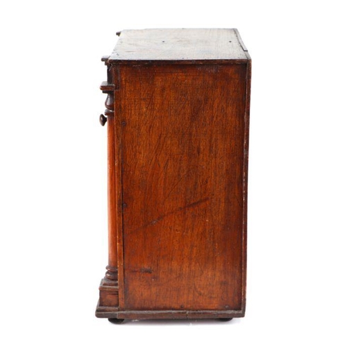 422 - A 19th century apprentice piece, a miniature cabinet, the pair of cupboard doors above three long dr... 