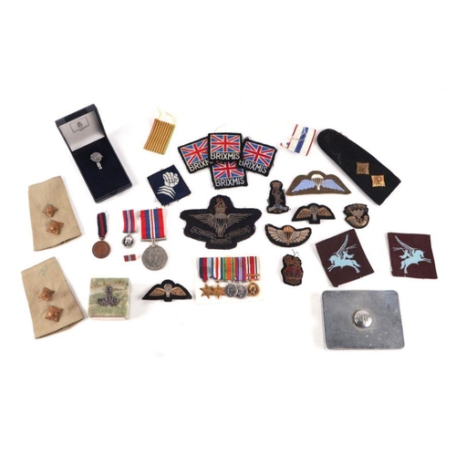 63 - Assorted militaria items to include an ARP tin, cap badges, buttons, flashes, a miniature group of f... 