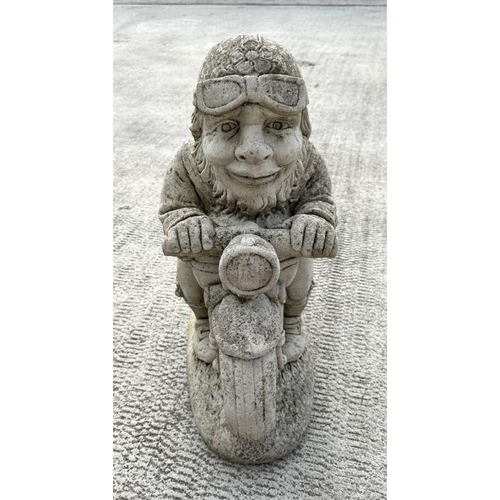 7 - A weathered concrete figure of a gnome riding a motorcycle,58cms high; together with a similar figur... 