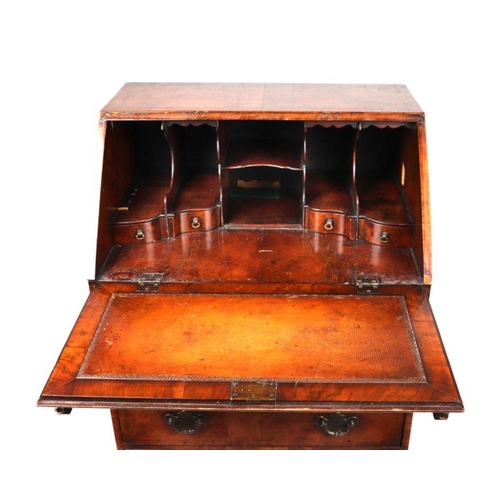 866 - A George II style walnut bureau, the fall-front revealing a fitted interior above three long drawers... 