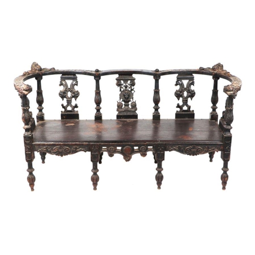 899 - An early 19th century continental oak window seat with cherub head and griffin carvings and dragon h... 