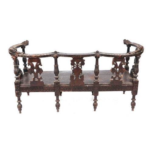 899 - An early 19th century continental oak window seat with cherub head and griffin carvings and dragon h... 