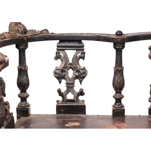 899 - An early 19th century continental oak window seat with cherub head and griffin carvings and dragon h... 