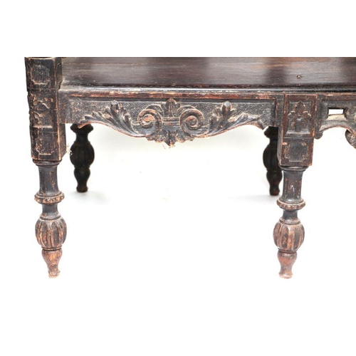 899 - An early 19th century continental oak window seat with cherub head and griffin carvings and dragon h... 