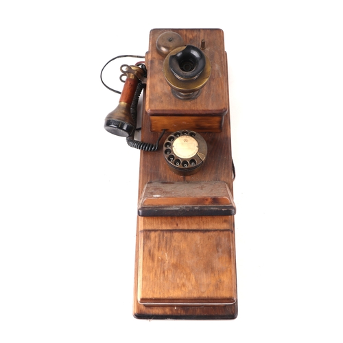 410 - A wall mounted Western Electric type telephone with spin dial, separate hand and ear piece, 58cms hi... 