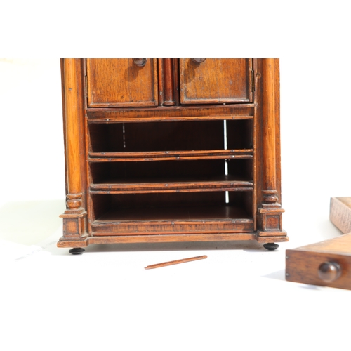 422 - A 19th century apprentice piece, a miniature cabinet, the pair of cupboard doors above three long dr... 