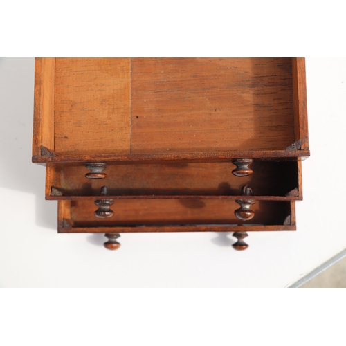 422 - A 19th century apprentice piece, a miniature cabinet, the pair of cupboard doors above three long dr... 