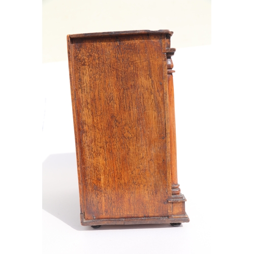 422 - A 19th century apprentice piece, a miniature cabinet, the pair of cupboard doors above three long dr... 