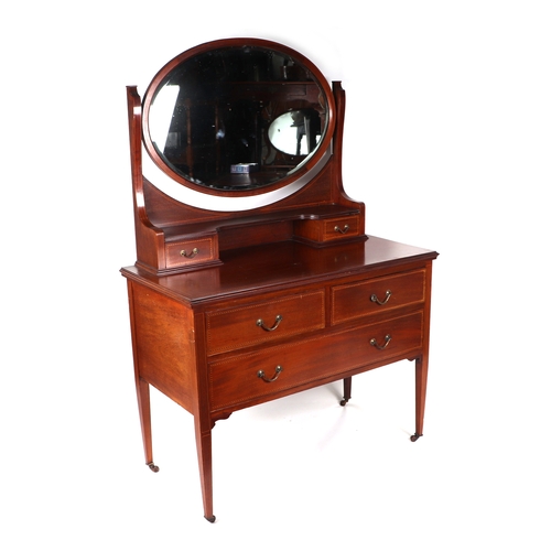 896 - An Edwardian inlaid mahogany dressing chest, the oval mirror above two short jewellery drawers with ... 