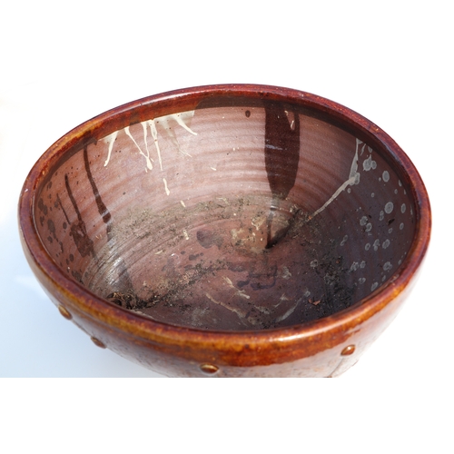 317 - A Studio pottery slipware planter on tripod base, initialled 'GC' to the underside, 40cms diameter; ... 