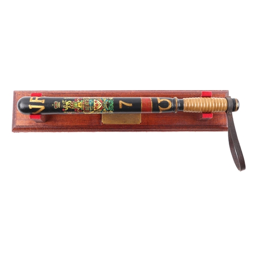 116 - A repainted Victorian Police truncheon 45cms (17.75ins) long on a wooden mount with brass plaque whi... 