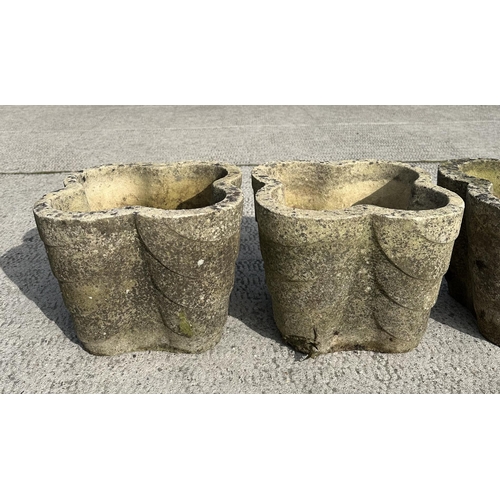 62 - A set of four well weathered reconstituted stone lobed form planters, 32cms wide; together with a te... 