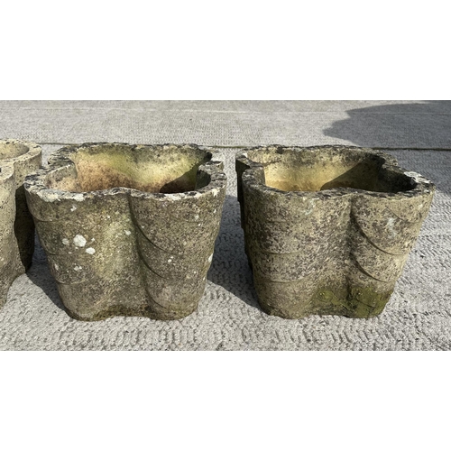 62 - A set of four well weathered reconstituted stone lobed form planters, 32cms wide; together with a te... 
