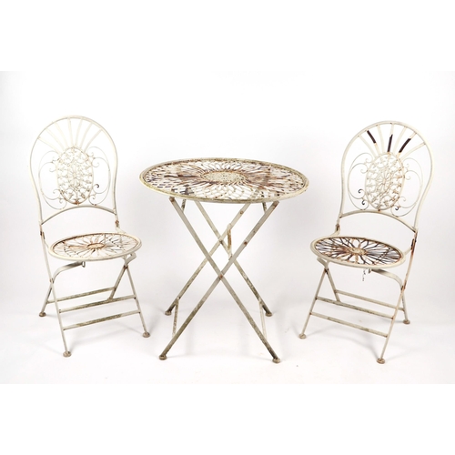 67 - A French style three piece painted metal patio set comprising a table, 70cms diameter, and two confo... 