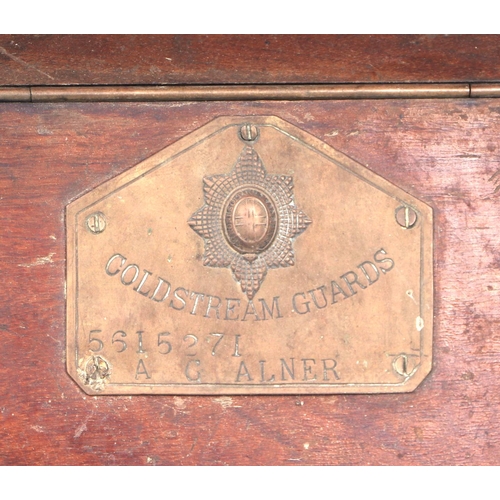 97 - An oak purdonium bearing a brass plaque for the Coldstream Guards and applied badges, 34cms wide.