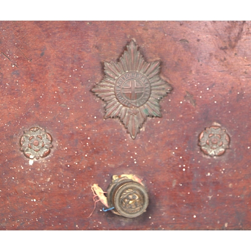 97 - An oak purdonium bearing a brass plaque for the Coldstream Guards and applied badges, 34cms wide.
