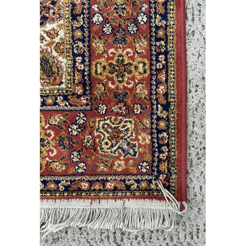 124 - A silk and cotton rug, the central medallion within a multi floral border, 170 by 123cms.