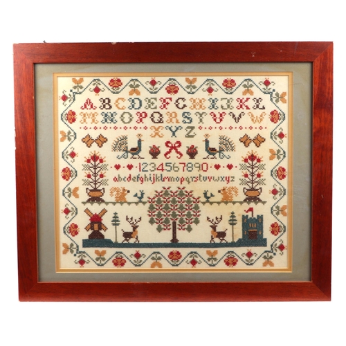 125 - A 19th century style cross stitch sampler with alphabet, numbers and animals within a wavy foliate b... 