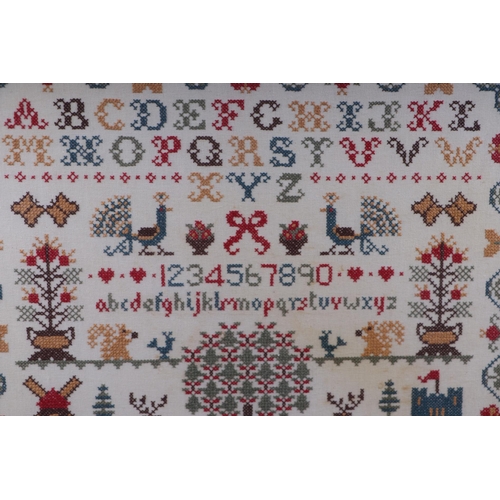 125 - A 19th century style cross stitch sampler with alphabet, numbers and animals within a wavy foliate b... 