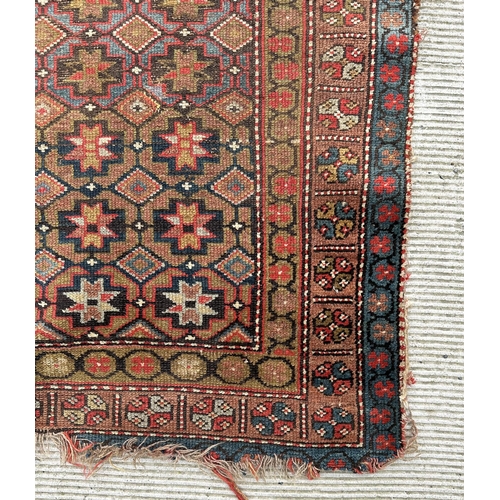 128 - A Persian rug with repeating geometric pattern in a multi border, on a brown ground, 170 by 95cms.