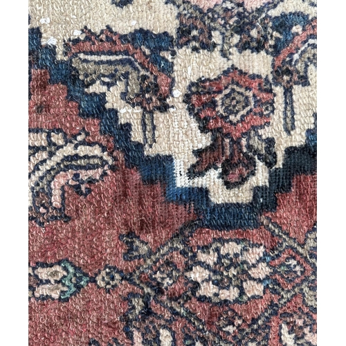 138 - A Persian hand knotted woollen Hamadan rug, the central gul within a stylised floral border, on a cr... 