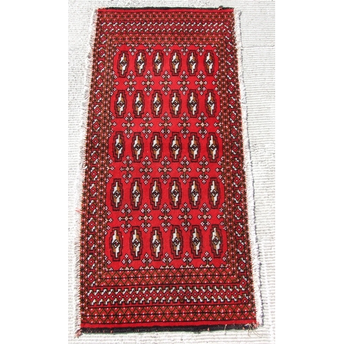 145 - Two small Persian Turkoman woollen hand-made rugs with geometric designs on a red ground, each appro... 