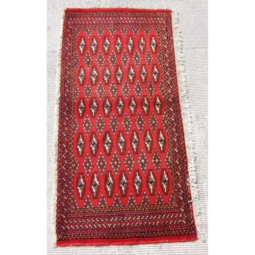 146 - Two small Persian Turkoman woollen hand-made rugs with geometric designs on a red ground, each appro... 