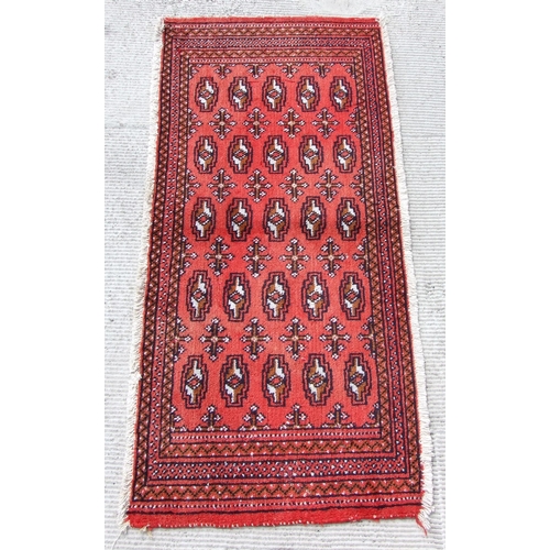 147 - Two small Persian Turkoman woollen hand-made rugs with geometric designs on a red ground, each appro... 