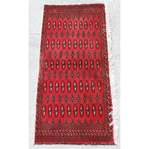 148 - Two small Persian Turkoman woollen hand-made rugs with geometric designs on a red ground, each appro... 