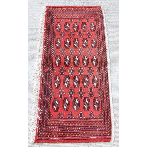 148 - Two small Persian Turkoman woollen hand-made rugs with geometric designs on a red ground, each appro... 