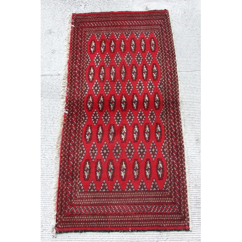 150 - Two small Persian Turkoman woollen hand-made rugs with geometric designs on a red ground, each appro... 