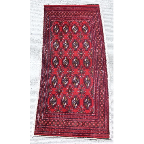 150 - Two small Persian Turkoman woollen hand-made rugs with geometric designs on a red ground, each appro... 