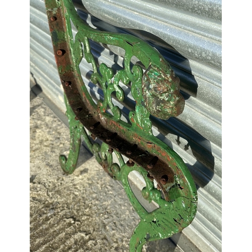 19 - A pair of Coalbrookdale style cast iron bench ends with lion mask scroll arms; together with a pair ... 