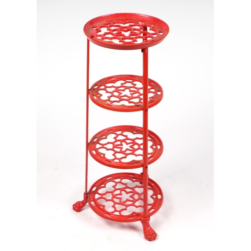 2 - A red painted cast aluminium four-tier pan stand, 70cms high.