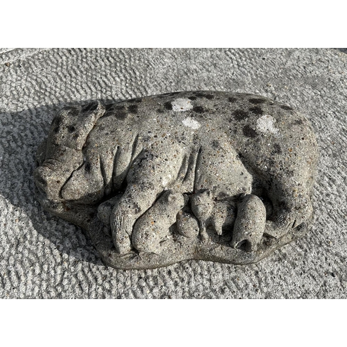 22 - A reconstituted stone recumbent pig and piglets, 50cms wide; together with another similar garden st... 