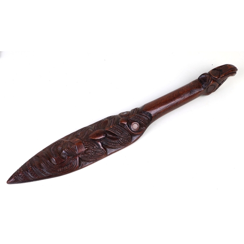 44 - A Maori carved wooden dance paddle with Tiki inlay decoration, 48cms long.