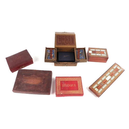 67 - A quantity of vintage playing cards, cribbage boards, dominoes and similar items.