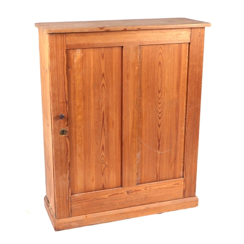 753 - A pine side cabinet with single twin panelled door enclosing a shelved interior, on a plinth base, 7... 