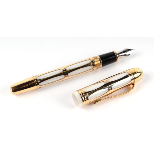 1032 - A white enamel and gilt fountain pen with iridium point nib, 14cms long.