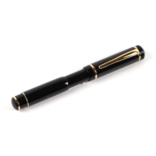 1033 - A black lacquer and gilt metal fountain pen with iridium point nib, 13cms long.