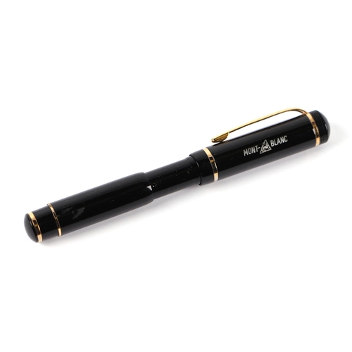 1033 - A black lacquer and gilt metal fountain pen with iridium point nib, 13cms long.