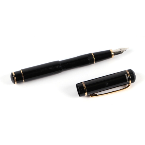 1033 - A black lacquer and gilt metal fountain pen with iridium point nib, 13cms long.