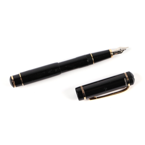 1033 - A black lacquer and gilt metal fountain pen with iridium point nib, 13cms long.