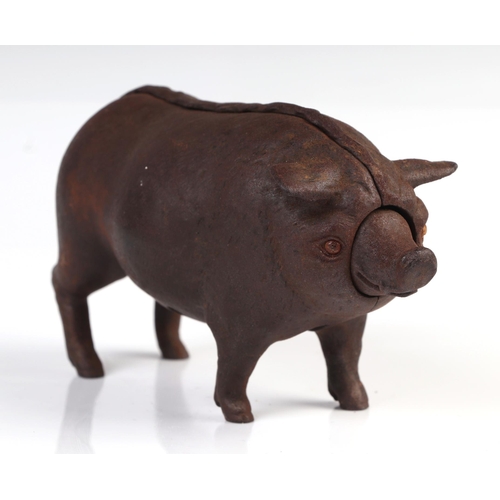 1040 - A cast iron mechanical clockwork table bell in the form of a pig with glass eyes, 14cm long